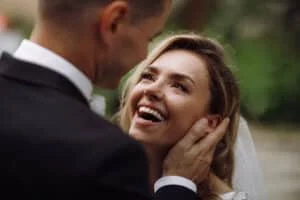 groom holds bride tender his arms while she looks him