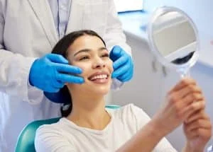 woman dentist happy with mirror dental surgery clinic teeth whitening treatment with doctor female patient satisfied smile consultation canal procedure oral care